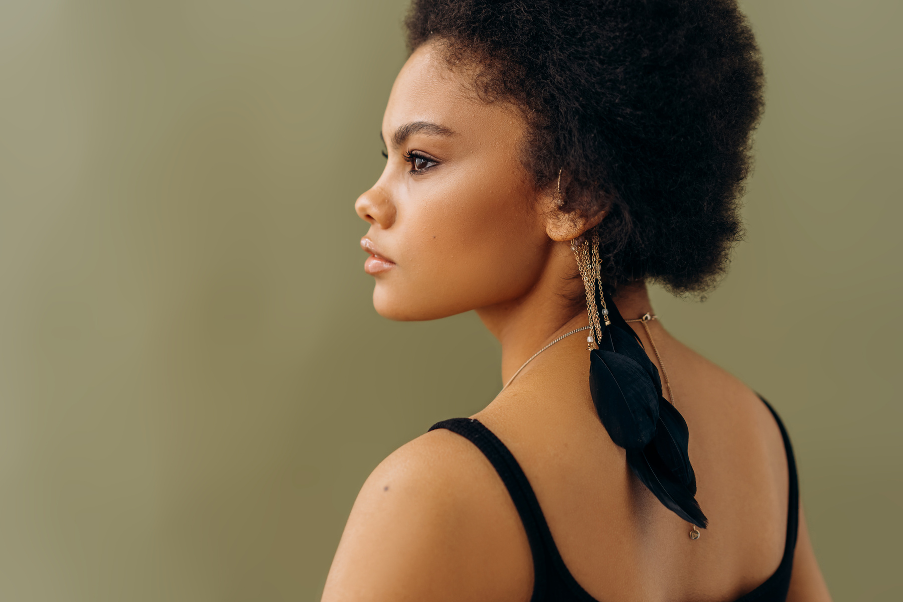 A Woman in Black tank Top Wearing Black Feather Earrings